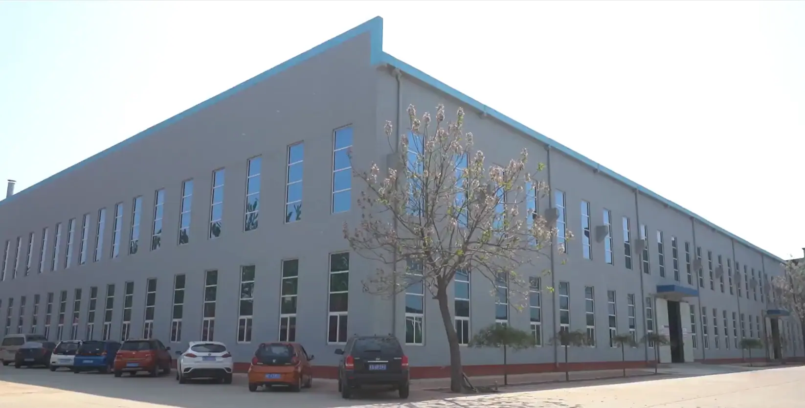 Factory exterior showing the front and side of the production building