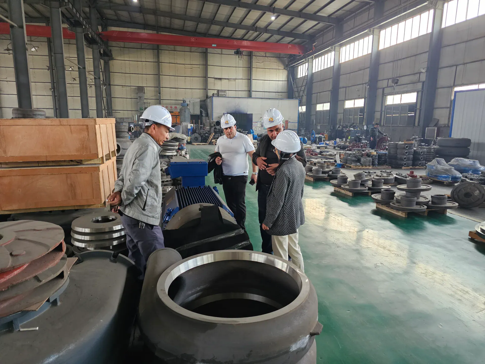 Visitors reviewing a large pump component in the workshop