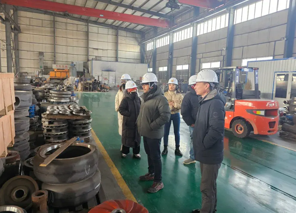 Visitors touring the factory among pump components and workshop equipment