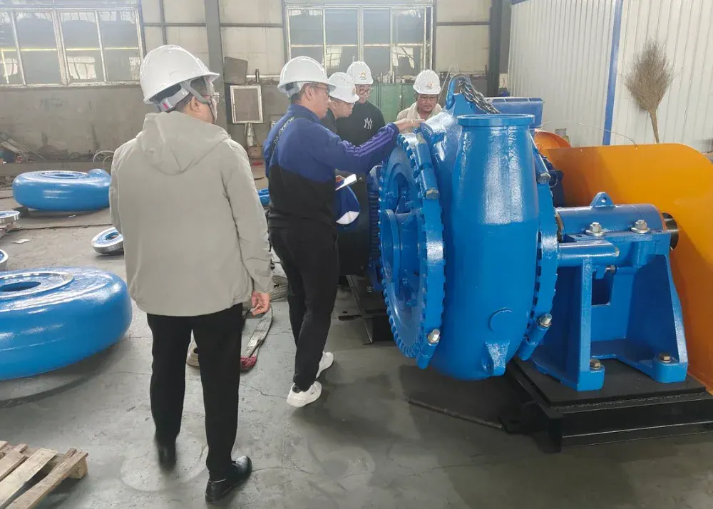 Visitors in hard hats reviewing a blue pump in the workshop