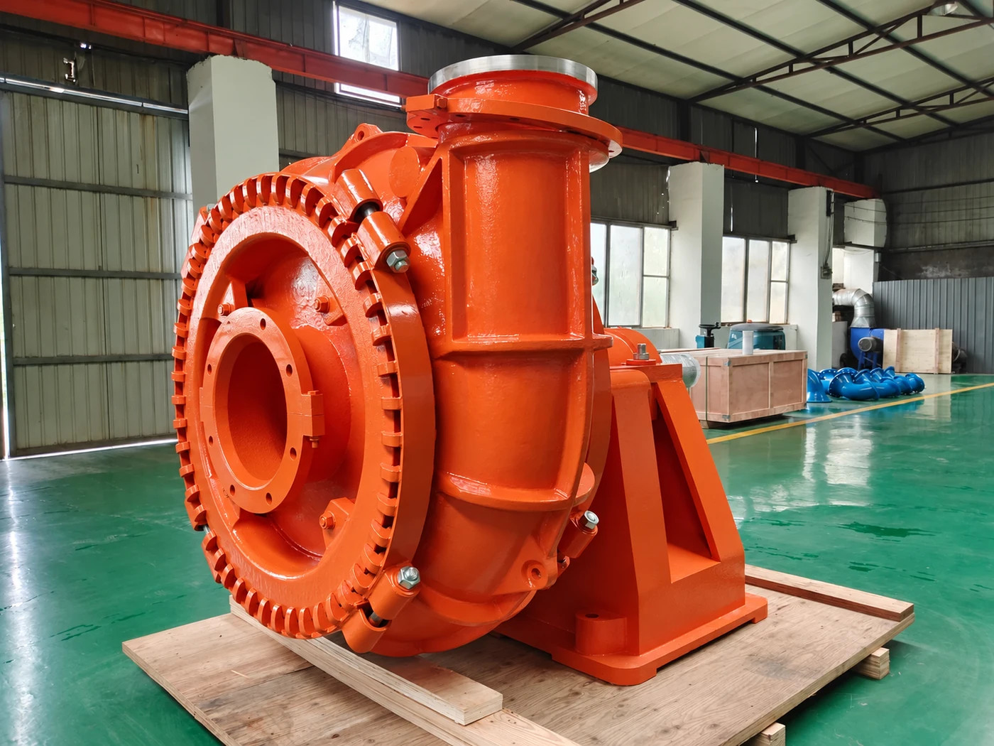 Illustration of an orange gravel pump with a large inlet flange and discharge outlet